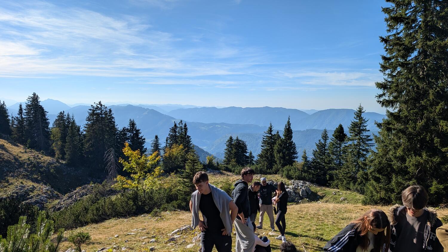 Jugendliche auf Bergwanderung in den österreichischen Alpen mit Blick auf die Bergketten
